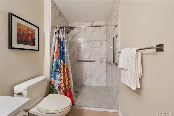 a white toilet sitting next to a shower curtain