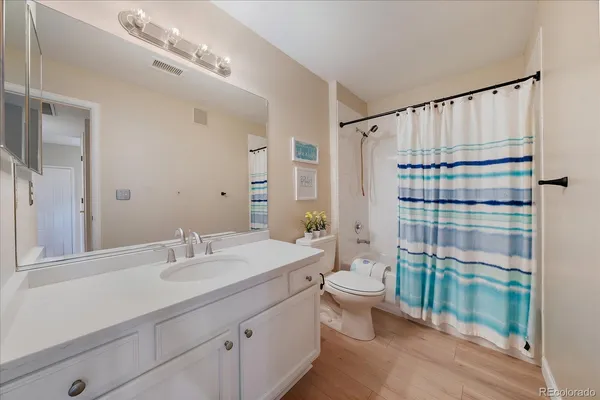 a bathroom with a double vanity sink toilet and shower