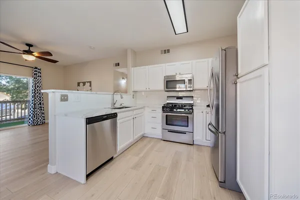 a kitchen with white cabinets and white appliances