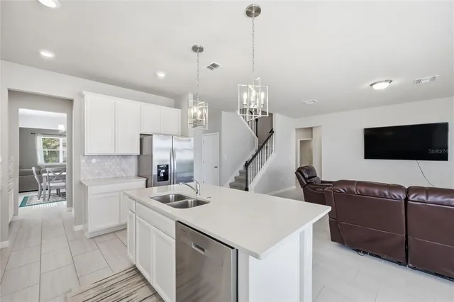 a living room with furniture window and a view of kitchen