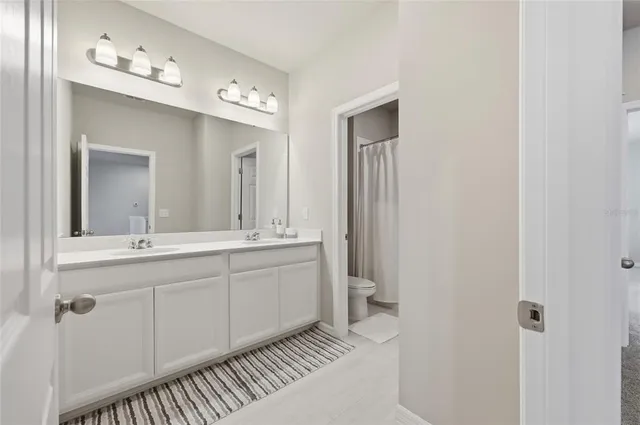 a spacious bathroom with a shower sink and mirror