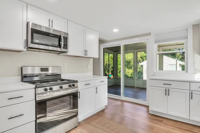 a kitchen with stainless steel appliances a stove microwave and sink