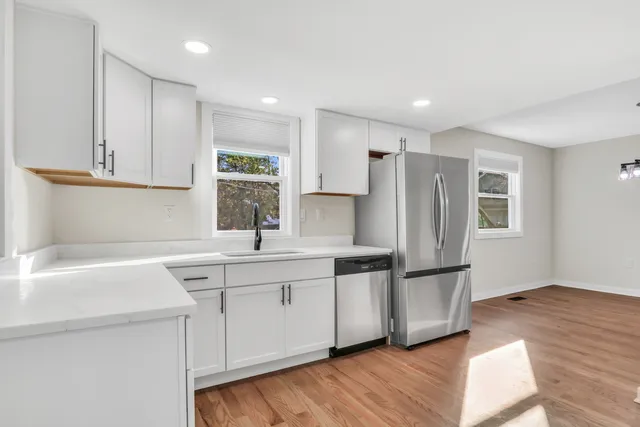 a kitchen with stainless steel appliances granite countertop a sink a refrigerator and a stove