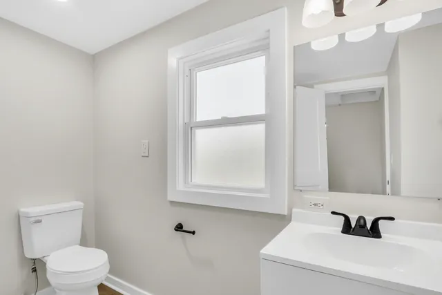 a bathroom with a sink a toilet and a mirror