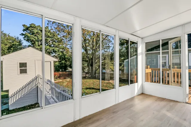 a view of a porch with a floor to ceiling window and wooden floor
