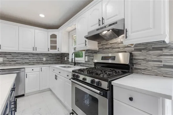 a kitchen with white cabinets and white appliances