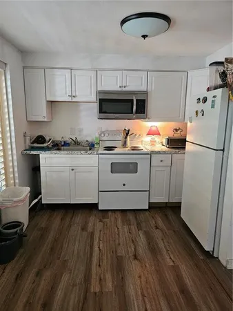 a living room with furniture flowerpot and wooden floor