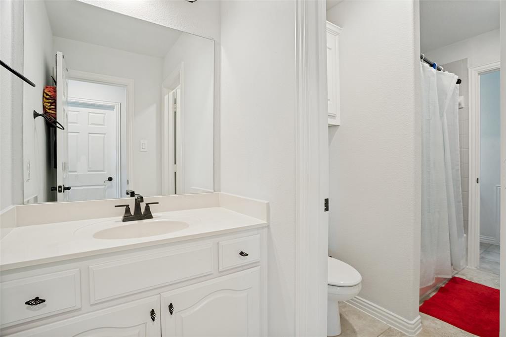1461 Ramsbury Lane Prosper, TX 75078 - Photo 19 of 30 Bathroom featuring a white vanity with an integrated sink, dark bronze-finish faucet, and a large wall-mounted mirror