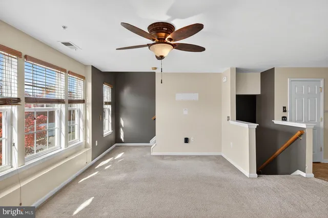 a view of an empty room with a ceiling fan