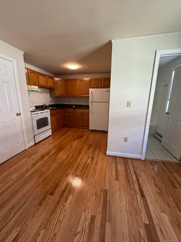 a view of a kitchen with wooden floor and electronic appliances