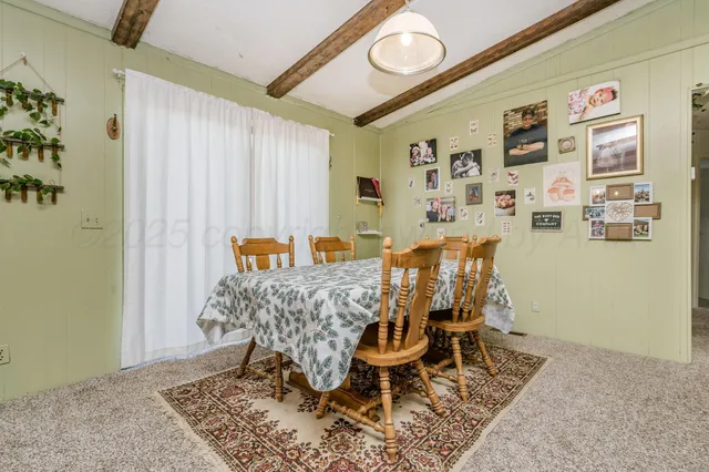 a kitchen with kitchen island a stove a sink a refrigerator dining table and chairs