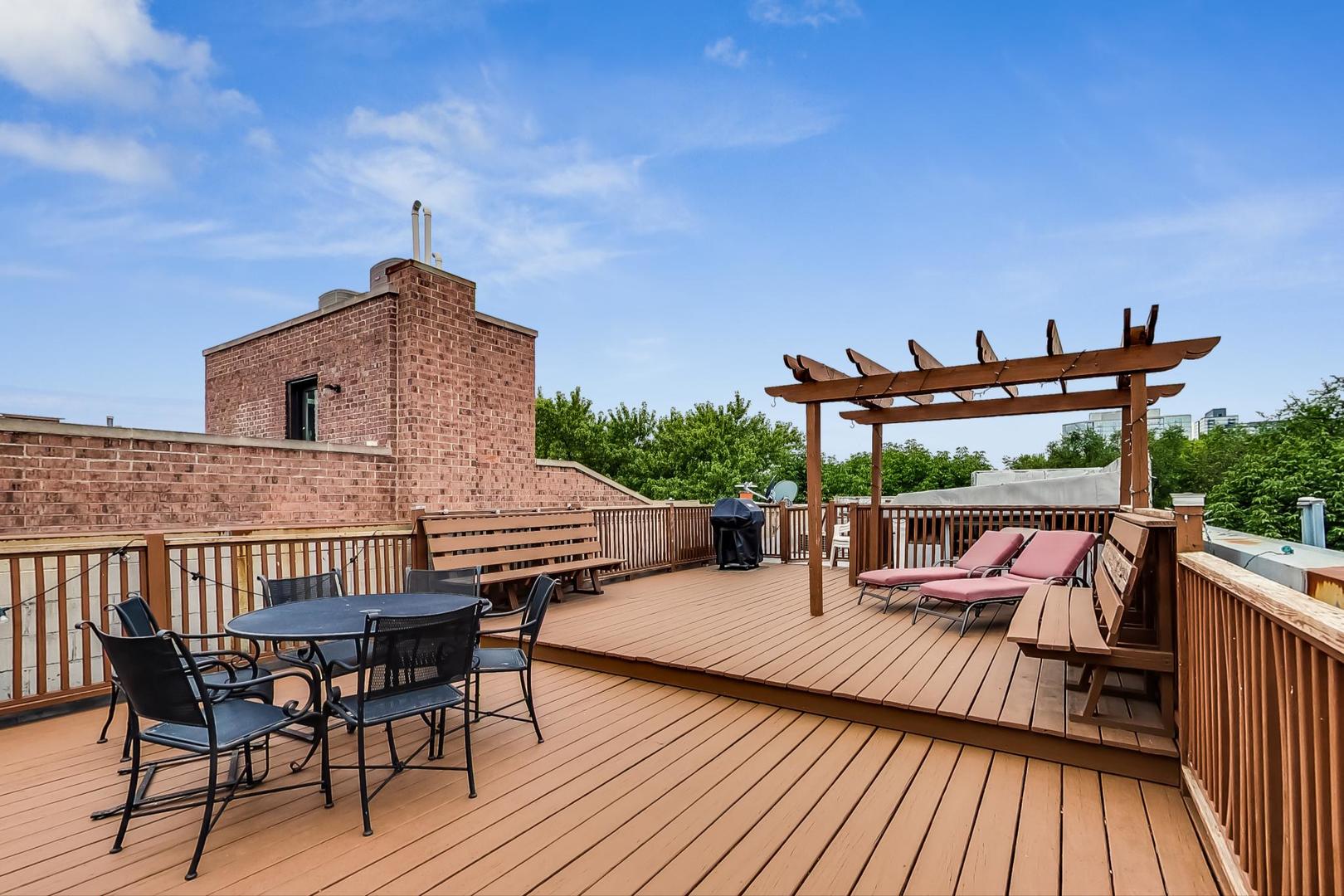 1407 North Mohawk Street, Unit G Chicago, IL 60610 - Photo 10 of 11 a view of deck with table and chairs a barbeque with wooden floor and fence