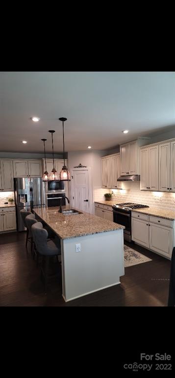 14100 Sunnyhill Grove Road Davidson, NC 28036 - Photo 2 of 18 a kitchen with kitchen island stainless steel appliances a sink a stove and cabinets
