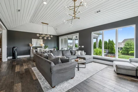 a kitchen with stainless steel appliances granite countertop a stove a sink dishwasher a dining table and chairs with wooden floor