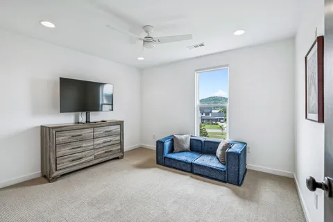 a large bedroom with a bed and a chair