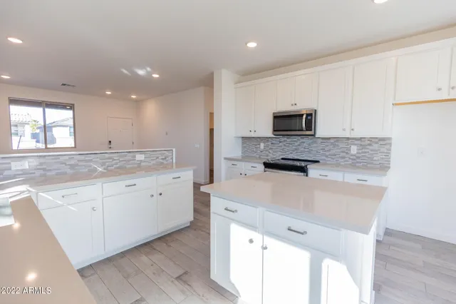 a kitchen with granite countertop white cabinets and black stainless steel appliances