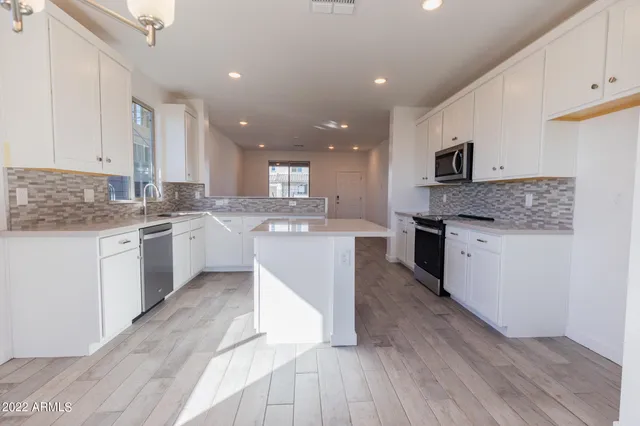 a kitchen with stainless steel appliances granite countertop a stove top oven a sink dishwasher and a refrigerator