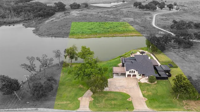 an aerial view of a house with a yard and lake view
