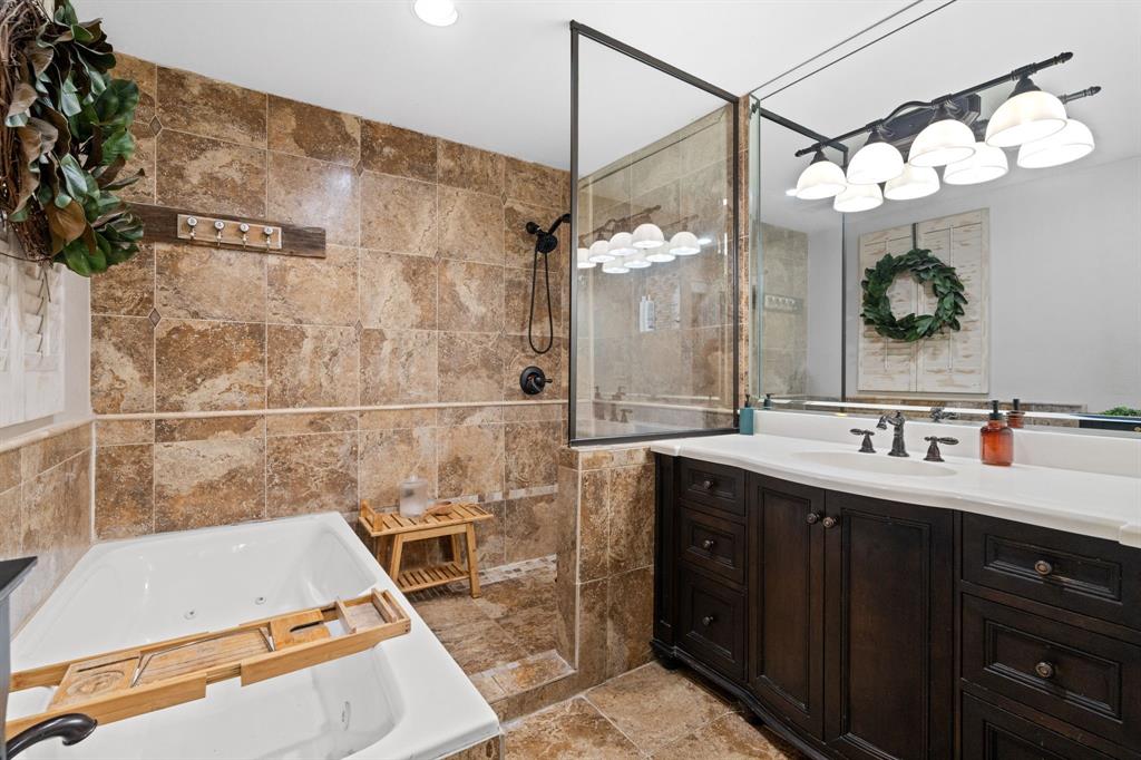 2402 Country Club Road Ennis, TX 75119 - Photo 12 of 33 a bathroom with a sink vanity granite tub and shower