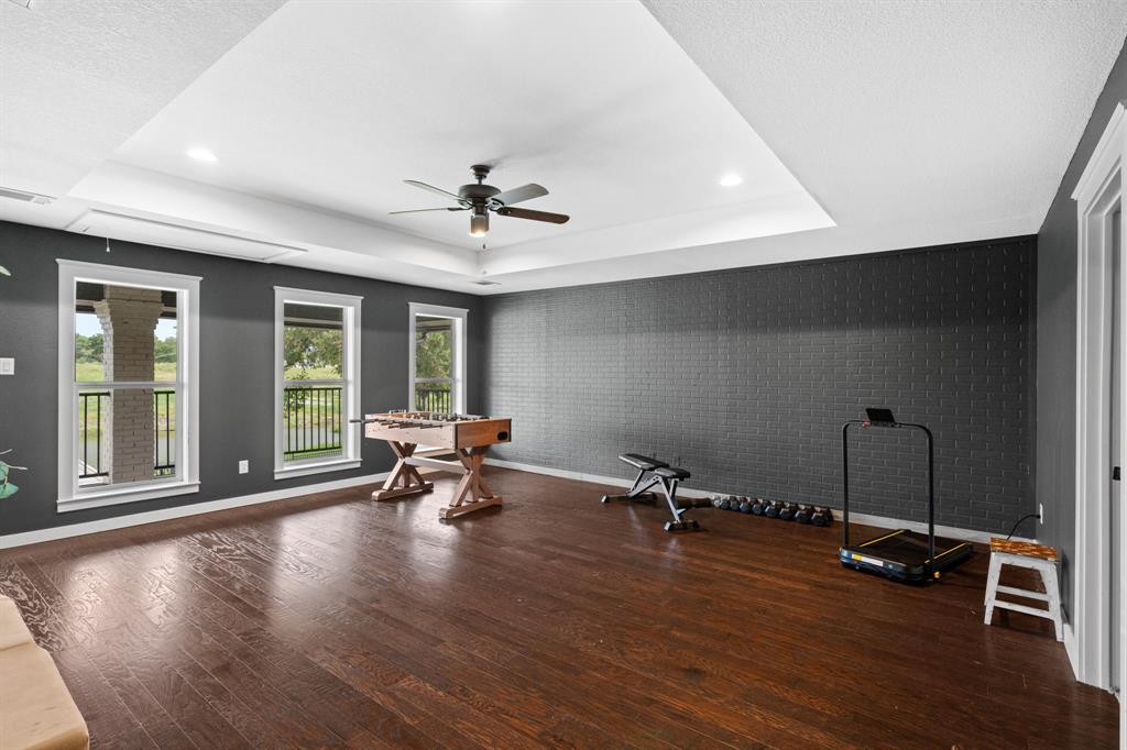 2402 Country Club Road Ennis, TX 75119 - Photo 17 of 33 a view of a room with gym equipment and wooden floor