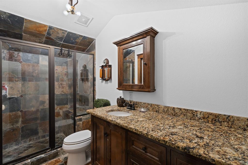2402 Country Club Road Ennis, TX 75119 - Photo 20 of 33 a bathroom with a granite countertop sink toilet and shower