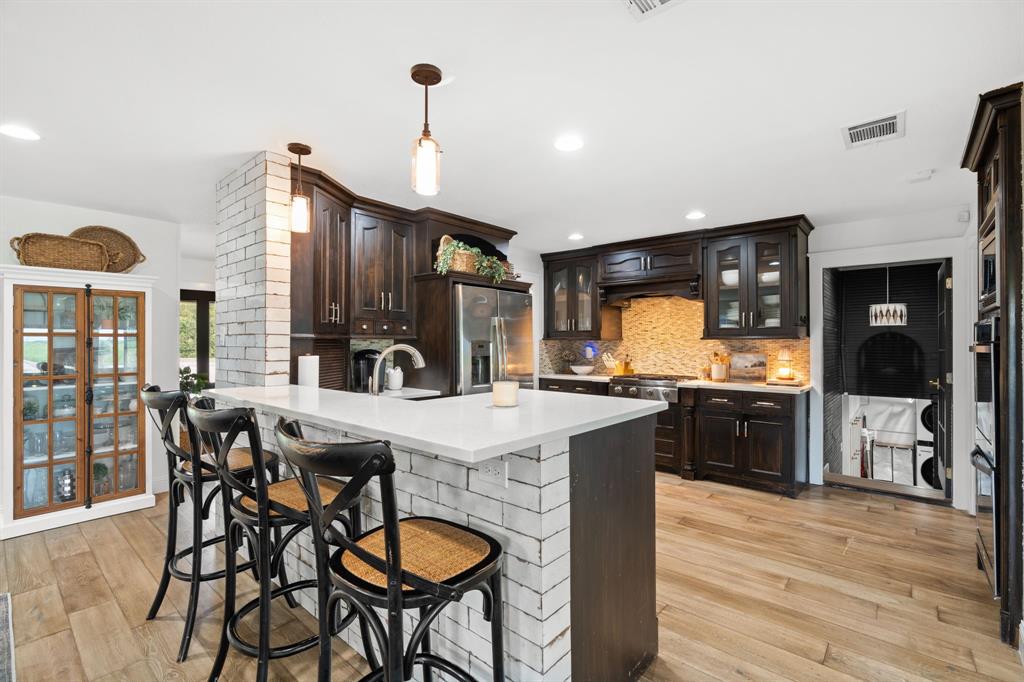2402 Country Club Road Ennis, TX 75119 - Photo 4 of 33 a kitchen with granite countertop a table chairs stove and refrigerator