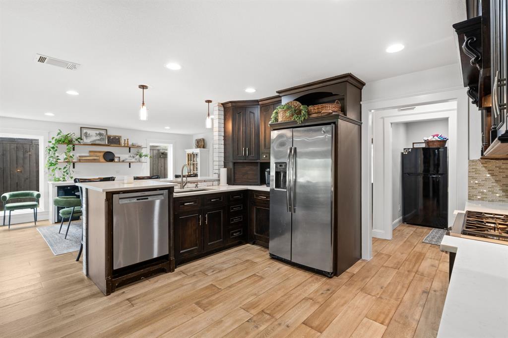 2402 Country Club Road Ennis, TX 75119 - Photo 5 of 33 a kitchen with stainless steel appliances granite countertop a refrigerator a sink a stove and oven