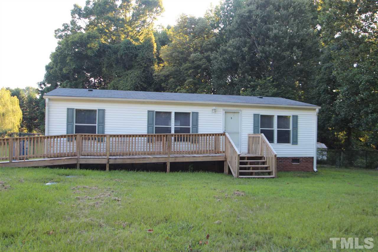 353 Oliver Loop Road Roxboro, NC 27574 - Photo 1 of 11 a front view of a house with a garden and deck