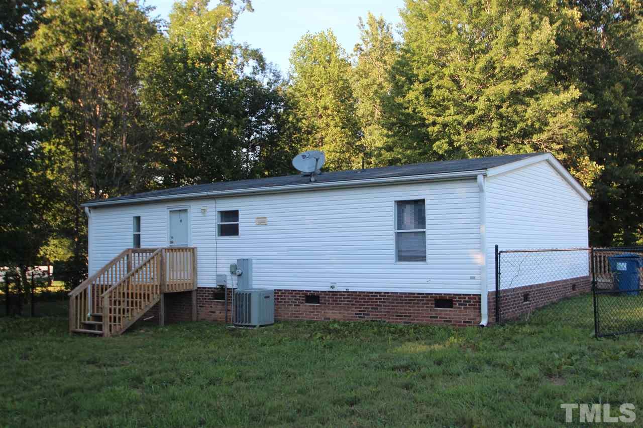 353 Oliver Loop Road Roxboro, NC 27574 - Photo 11 of 11 a view of a backyard with plants and large tree