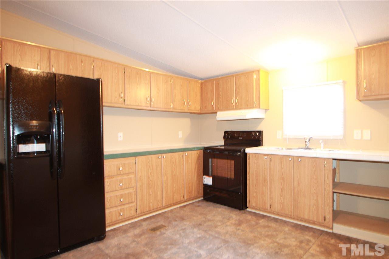 353 Oliver Loop Road Roxboro, NC 27574 - Photo 3 of 11 a kitchen with granite countertop a refrigerator and a sink