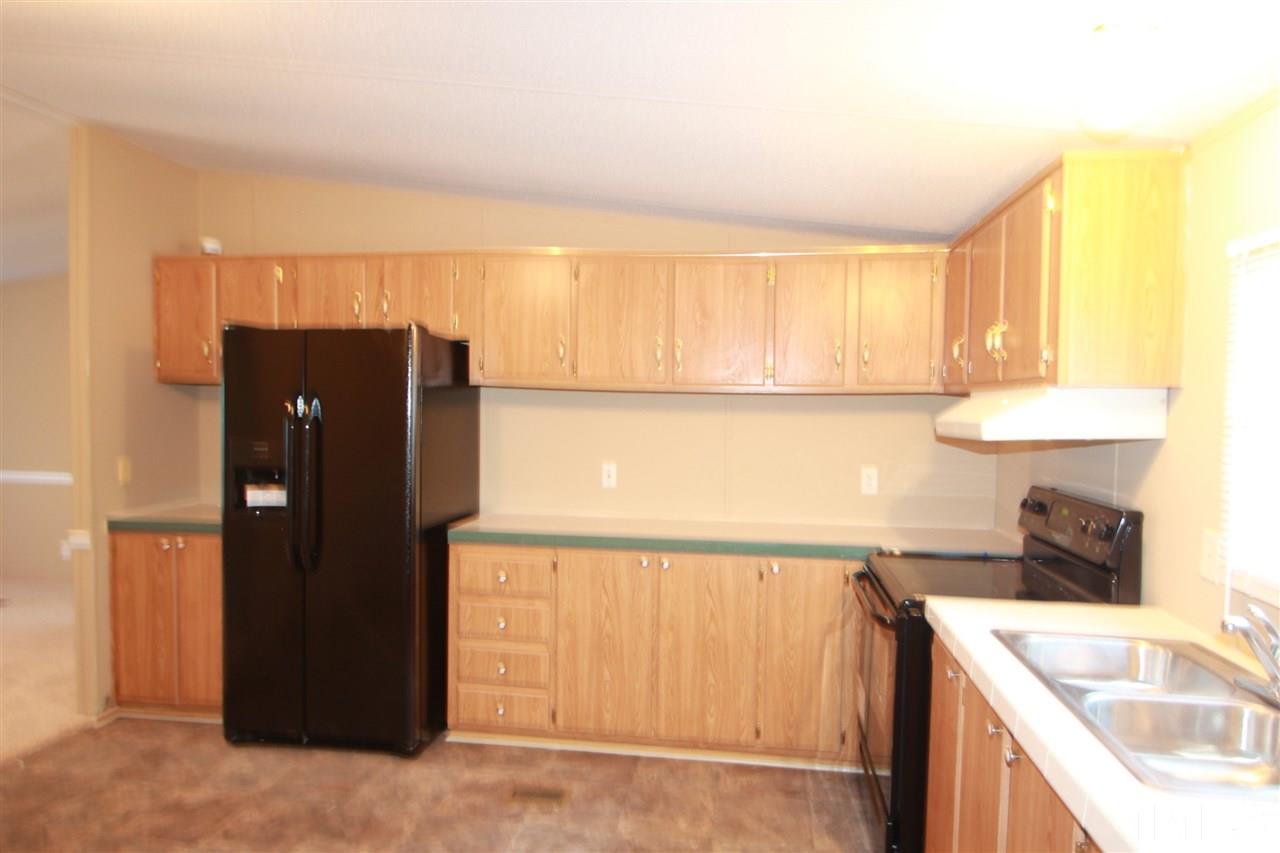 353 Oliver Loop Road Roxboro, NC 27574 - Photo 4 of 11 a kitchen with a refrigerator and a sink