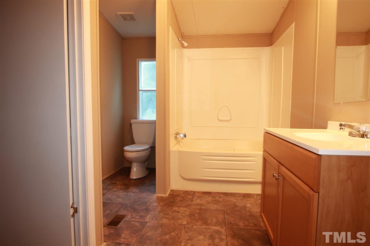 353 Oliver Loop Road Roxboro, NC 27574 - Photo 6 of 11 a bathroom with a sink a toilet and shower