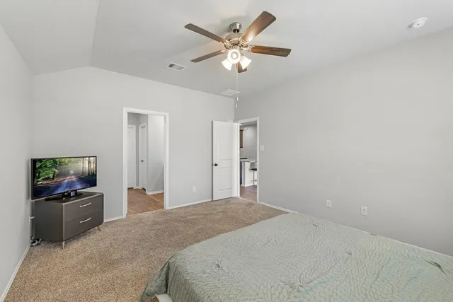 a bedroom with a large bed and a chandelier