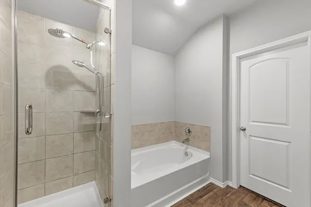 a bathroom with a tub shower and sink