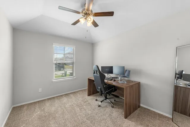 a view of a workspace with furniture and a window