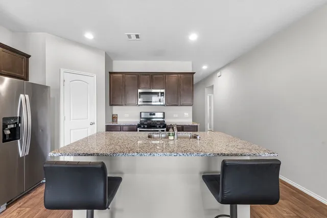 a kitchen with stainless steel appliances granite countertop a sink refrigerator and microwave