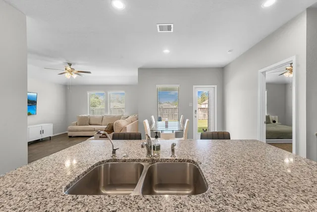 a kitchen with granite countertop a sink and a stove top oven