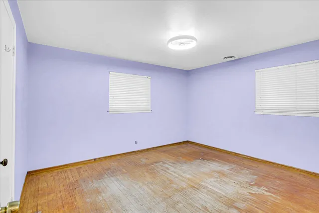 a view of a room with wooden floor and a window