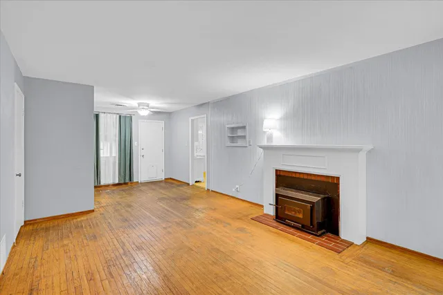a view of empty room with wooden floor and fireplace