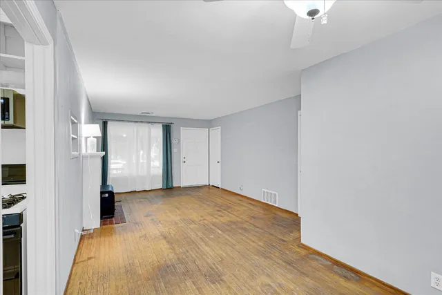 a view of empty room with wooden floor