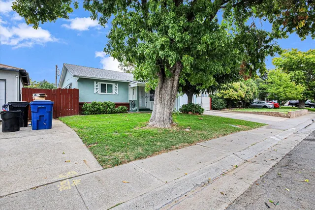 a front view of a house with a yard and potted plants
