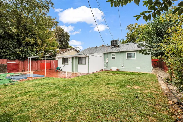a view of a house with a backyard and a tree