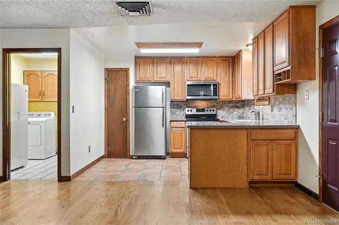 a kitchen with stainless steel appliances granite countertop a refrigerator a stove a sink and a microwave