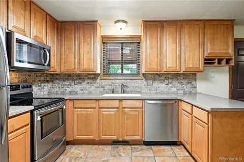 a kitchen with stainless steel appliances granite countertop a stove a sink and a microwave