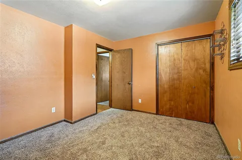 an empty room with a window and a ceiling fan