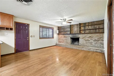 a view of an empty room with a fireplace and a window