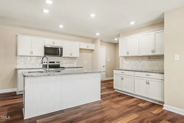 a kitchen with a sink stove and cabinets