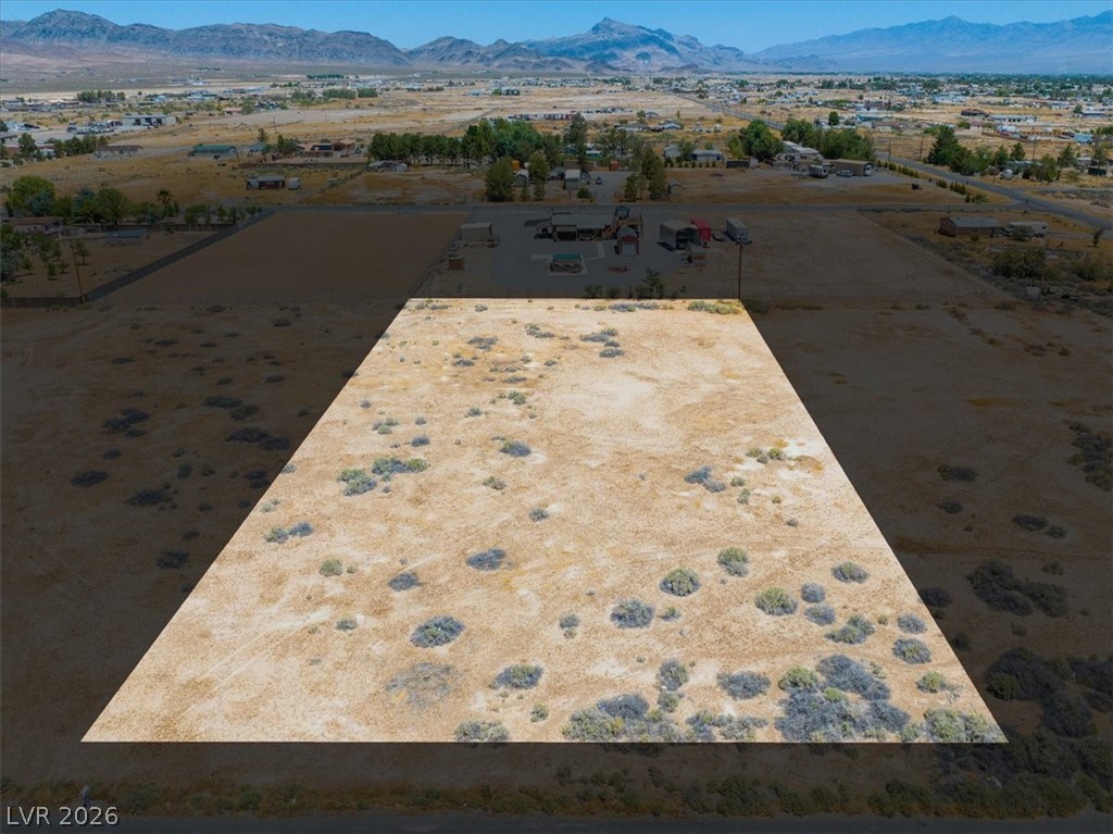 4580 Lawrence Road Pahrump, NV 89048 - Photo 3 of 40 A vast, undeveloped lot awaits your vision, framed by distant mountains and clear skies.
