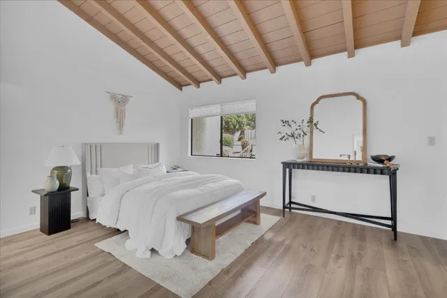 a bedroom with a bed and wooden floor