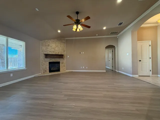 a view of an empty room with a fireplace and a window